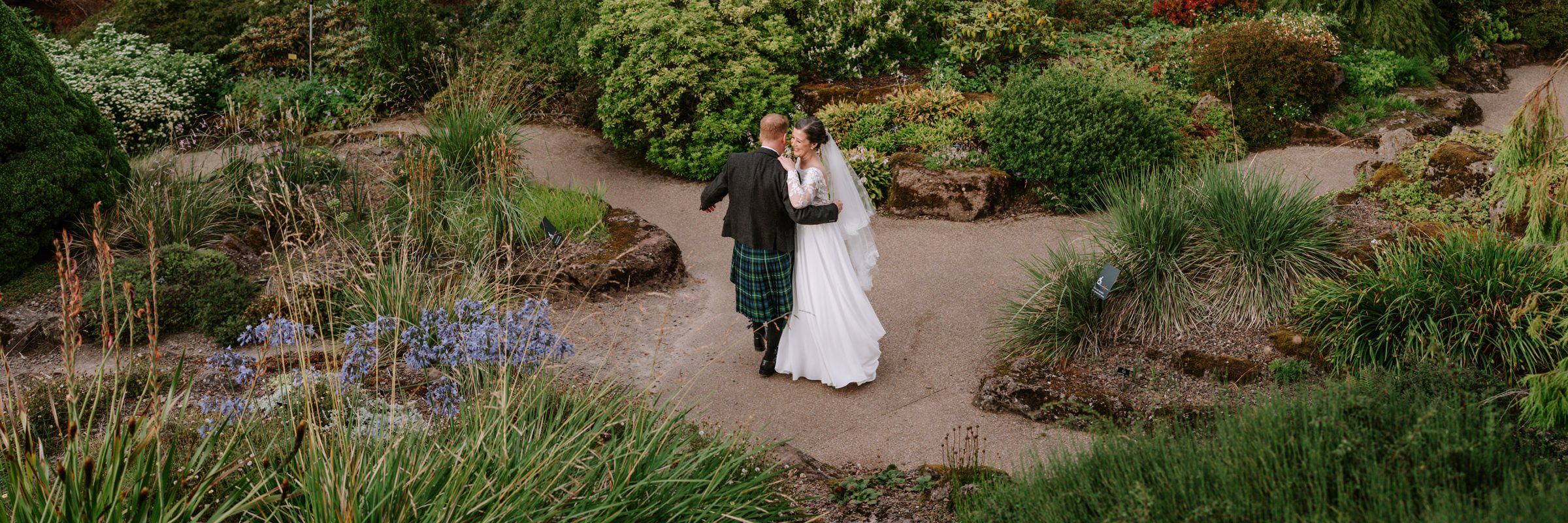 Kevin and Michelle walking through the garden on their wedding day